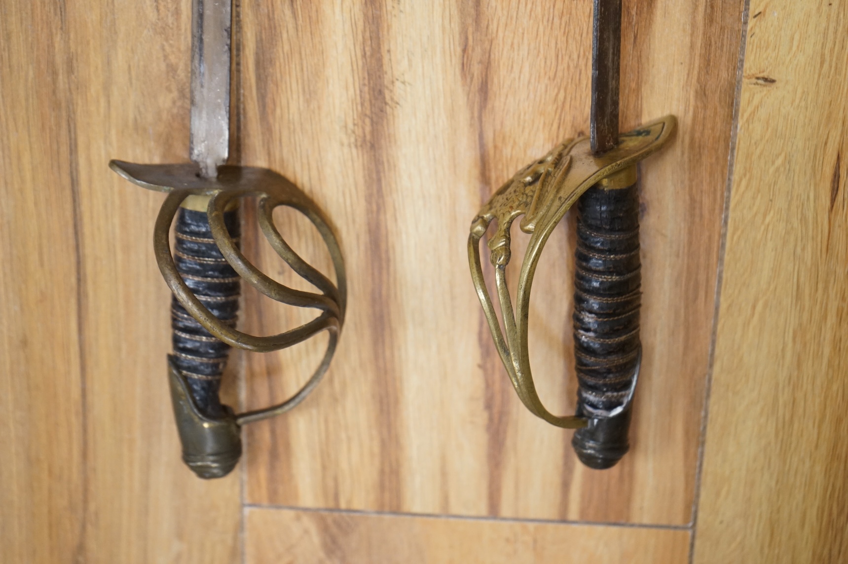 Two early 20th century Imperial German child’s swords with leather scabbards and hangers, blades 45.5cm